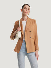 a woman in camel blazer and jeans